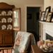 Cozy Southern living room vignette with heirloom china in an open cabinet, framed family photos on the mantel, and curated keepsakes including a vintage quilt and seashells.