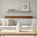 Bright Southern living room with neutral linen sofa cushions, a single sculptural vase on a clean coffee table, and an uncluttered shelf displaying a few coastal finds.