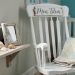 Cozy coastal-style nursery corner with a shelf of seashells, a driftwood-style frame, and a vintage quilt on a rocker near a crib.